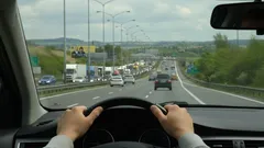 Pohled z auta na dálnici, ruce na volantu, dopravní provoz, jízda po silnici