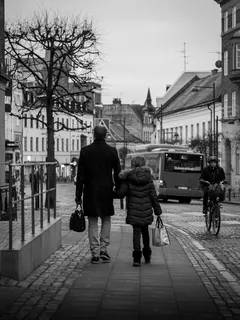 Černobílá fotografie muže a ženy jdoucích po chodníku