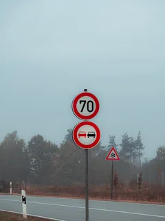 Červené a bílé značky u silnice na okraji vozovky