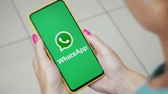 Žena drží mobil s otevřenou aplikací WhatsApp na zelené obrazovce